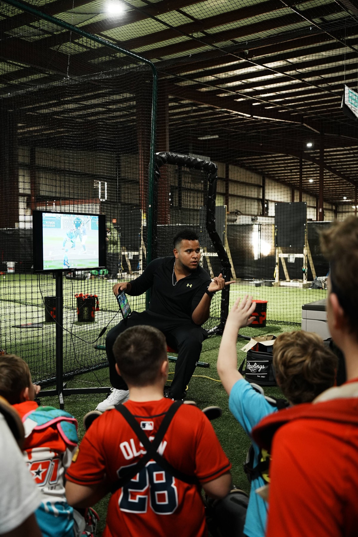 Coach Andrés teaching game situations to a group of catchers using video