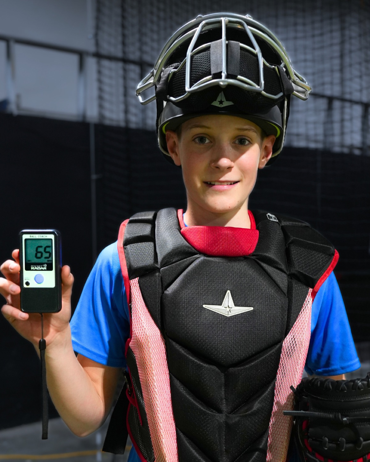Young catcher holding a Pocket Radar after measuring throwing velocity
