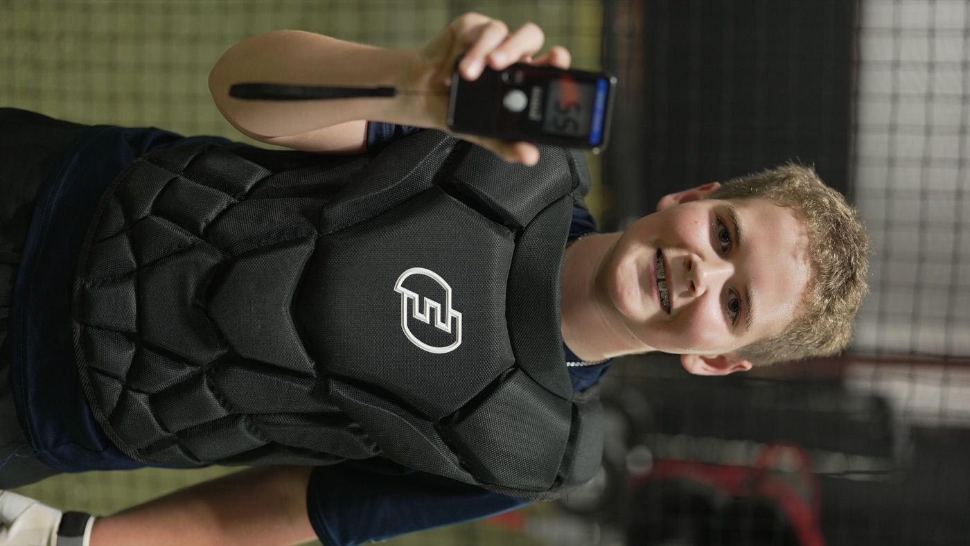 Catcher in gear holding a radar device after a training rep